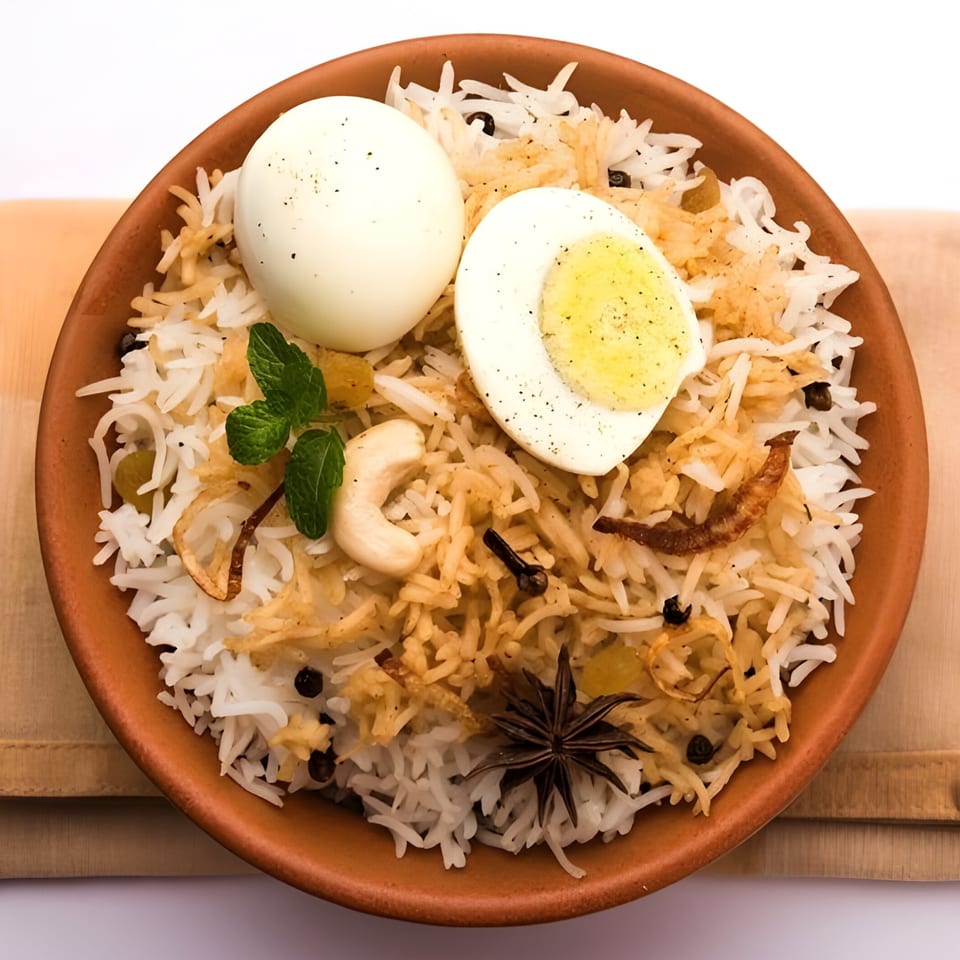 Spice Venue's Egg Biryani, a clay pot filled with rice, whole and halved boiled eggs, and spices.